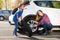 Happy mother and son changing flat tire together