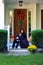 Happy mother and son sitting on the porch of the autumn decorated house