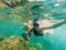 Happy mother and son snorkeling on beach