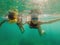 Happy mother and son snorkeling on beach