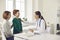 Happy mother and son talking to friendly pediatrician during visit to the hospital