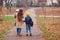 Happy mother and sons going to school and to kindergarten. Mother with two sons on walk in autumn. Back to school. Happy family in