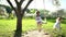 Happy mother swinging with her daughters on swing on sunlight. Static shot.