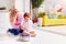 Happy mother and toddler son poking fingers in birthday cake