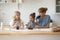 Happy mother and two adorable daughters having fun in kitchen