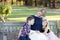 Happy mother with two children sitting on a wooden bench in a garden