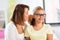 Happy mother whispering secret to daughter at home