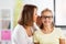 Happy mother whispering secret to daughter at home