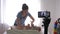 Happy motherhood, popular vlogger woman changes clothes of baby boy while recording teaching video on mobile phone for