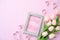 Happy mothers day concept. pink tulip flower with paper heart and Picture Frame with LOVE MOM text on pink pastel background