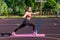 Happy motivated athletic woman doing sports, standing on rubber stripe training legs, exercising with rubber expander