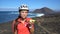 Happy mountain biking woman eating healthy fruit doing thumbs up