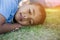 Happy mulatto boy child is smiling enjoying adopted life. Portrait of young boy in nature, park or outdoors. Concept of happy