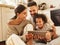 Happy multi ethnic family: parents and son laughed and watch funny video on a tablet  at home