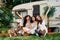 Happy multi ethnic girls raised arms posing near camper van outdoors