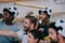 happy multicultural friends in soccer ball hats celebrating gesturing by hands and watching football match