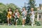 Happy multicultural schoolchildren running on lawn in park together