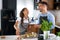 Happy multiethnic couple preparing home made tomato and basil pasta. Cooking at home