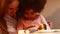 happy multiethnic family eating rainbow cake at kitchen