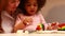 happy multiethnic family eating rainbow cake at kitchen