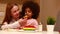 happy multiethnic family eating rainbow cake at kitchen