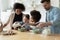 Happy multiethnic family with kids baking in kitchen together