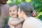 Happy multiethnic parents and amazed mixed race baby. Mixed race family outdoor portrait. Happy biracial family hug baby