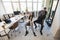 Happy multiracial colleagues group having fun together, riding on chairs in office, diverse excited office workers enjoying break