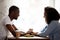 Happy multiracial couple holding hands, enjoying date in cafe