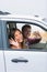 Happy multiracial couple leaving for road trip on summer vacation holiday. Young people driving car to travel