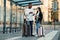 Happy multiracial couple look at boarding pass checking departure time at the stop near airport.