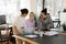 Happy multiracial female colleagues laugh working together on laptop