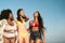 Happy multiracial females with different body size having fun walking on the beach during summer holiday