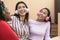 Happy multiracial friends having fun listening music with wireless headphones on house patio