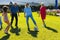 Happy multiracial multigeneration family playing soccer on grassy land in yard on sunny day