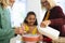 Happy multiracial multigeneration female family preparing baked food on table in kitchen