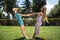 Happy multiracial young lesbian couple hold hands in the park.