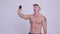 Happy muscular bearded tourist man vlogging with phone shirtless