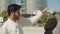 Happy muslim couple performing traditional dance outside.