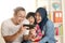 Happy muslim family looking at smart phone together, mother father and baby girl daughter playing games or doing video call at
