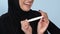 Happy muslim female holding positive pregnancy test, friends congratulations