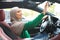 Happy muslim lady driving alone adjusting rearview mirror