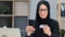 Happy Muslim woman in black hijab online shopping digital card payment smartphone application