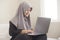 Happy Muslim Woman Working with Laptop in Her Bedroom