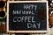 Happy national coffee day. Words on blackboard flat lay