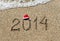 Happy new year 2014 with christmas hat on sandy beach - holiday