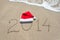 Happy new year 2014 with santa hat on sea beach sand with wave