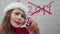 Happy New Year 2018. Santa girl writes on glass words 2018 with lipstick. Beautiful girl in Santa hat sending a message.