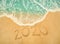 Happy New Year 2020 written on seashore sand at sunrise concept
