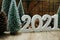 Happy New Year 2021 festive background with christmas tree and pine cone decoration on wooden background